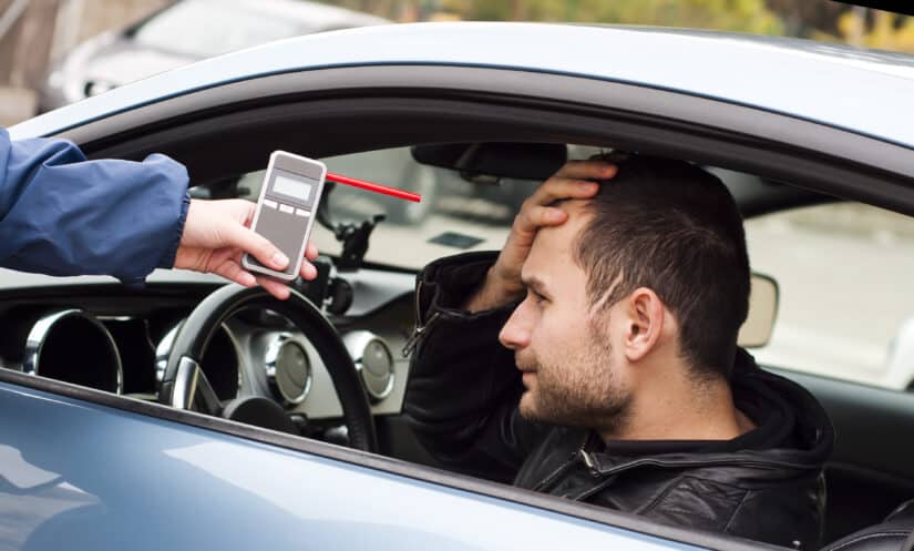 The policeman showing the man a breathalyzer